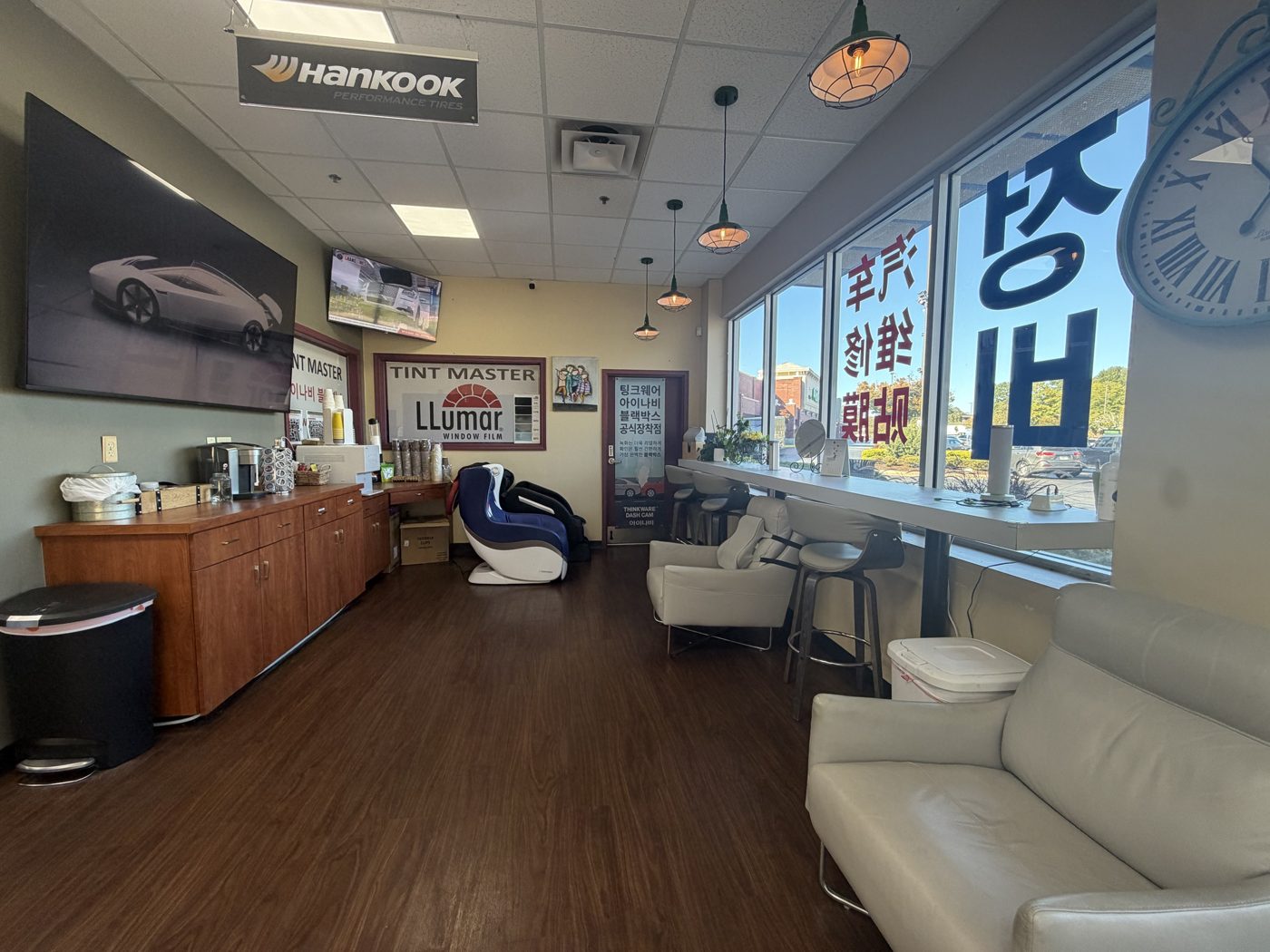 Customer lounge with coffee bar, massage chairs, leather seating, and a window counter